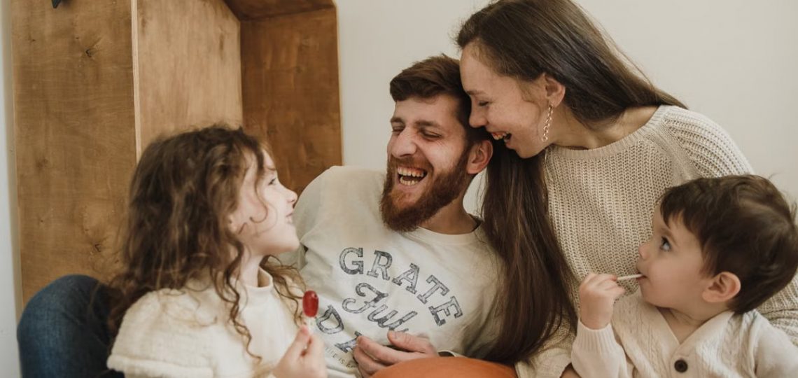 Happy family enjoying quality time with their children indoors, sharing laughter and joy.